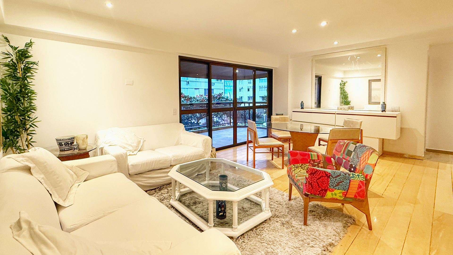 Sala ampla anexa à varanda com opção de fechamento.